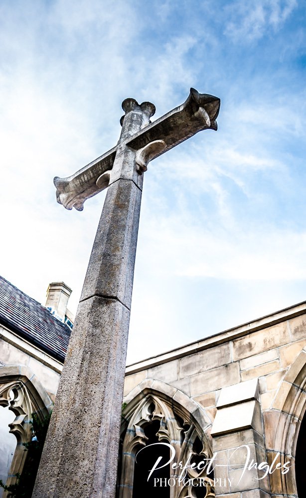 Stone cross against sky at a Gothic church cloister
