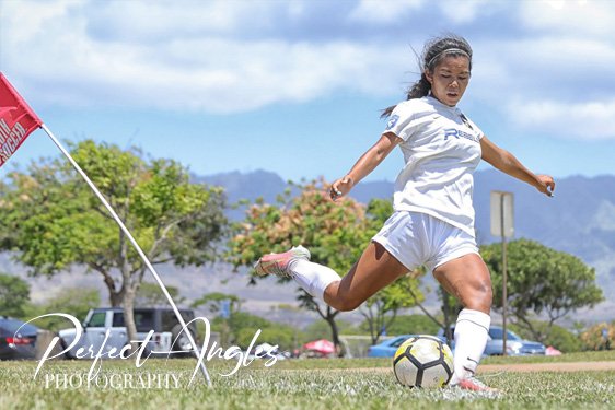 Female soccer player striking the ball