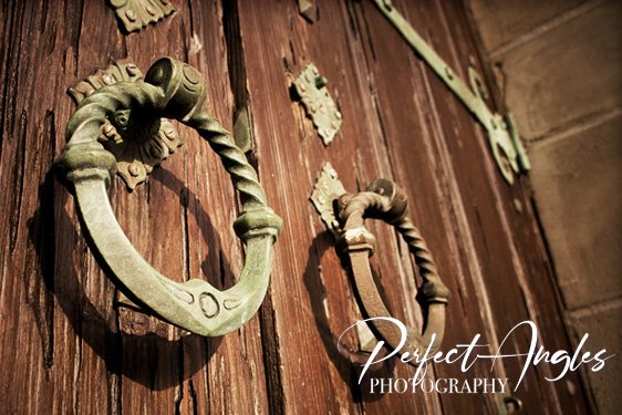 Ornate antique door knockers on a wooden door