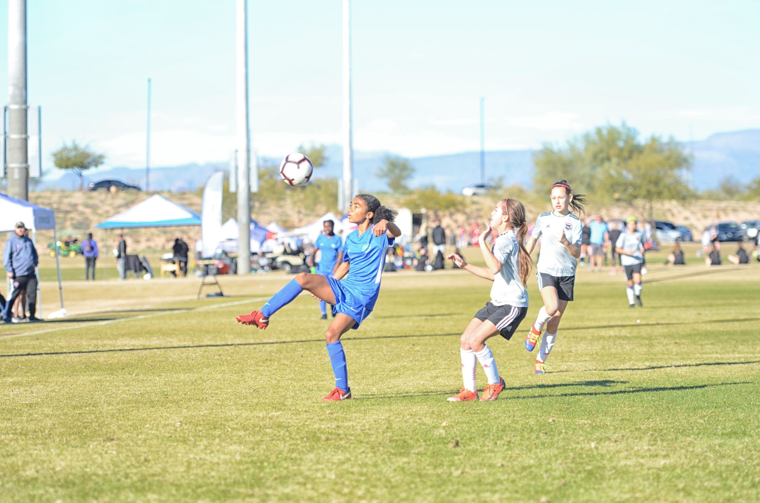 A female soccer player with her back against an opponent